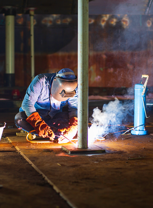 Welder repairing a steel structure using stick welding